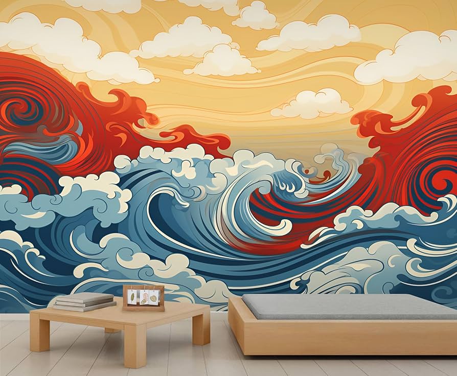 A minimalist bedroom featuring a large, stylized wall mural of crashing ocean waves in blue, red, and white. The artwork is influenced by Japanese Ukiyo-e style, set against a golden sky with soft white clouds. A low wooden platform bed and a simple coffee table sit in the foreground.