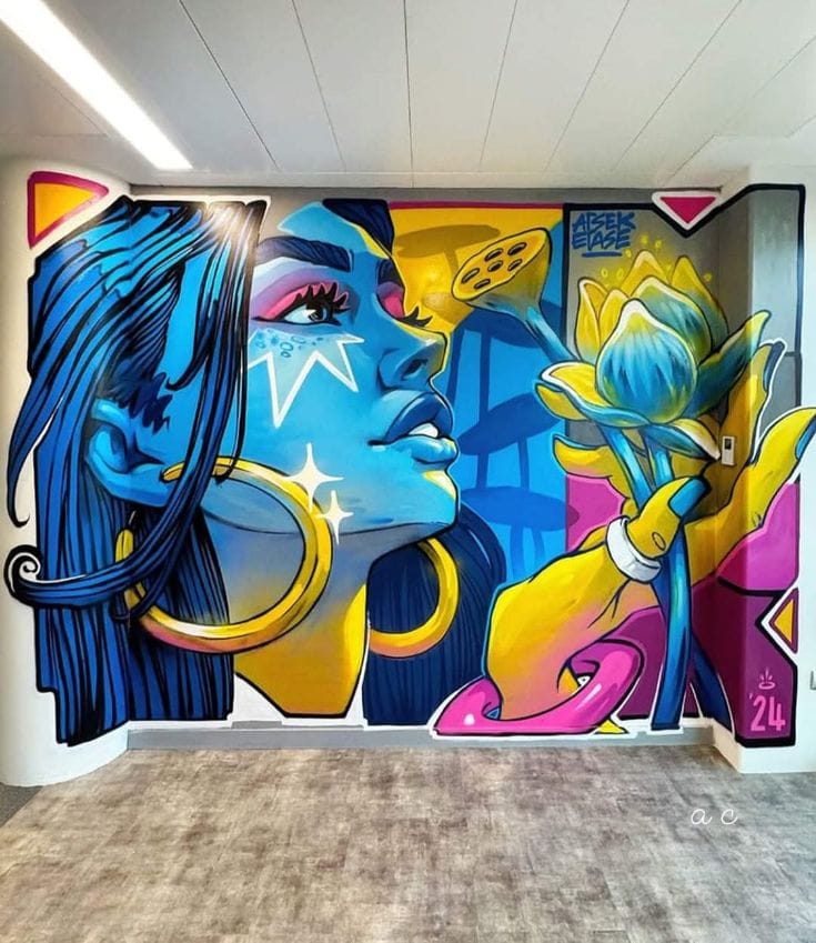 Stylized blue-skinned woman holding a glowing lotus flower on a corner wall.