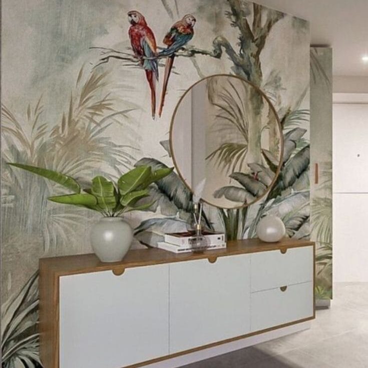 Tropical wall mural with colorful parrots on a tree branch and lush foliage behind a modern console table in a contemporary interior.