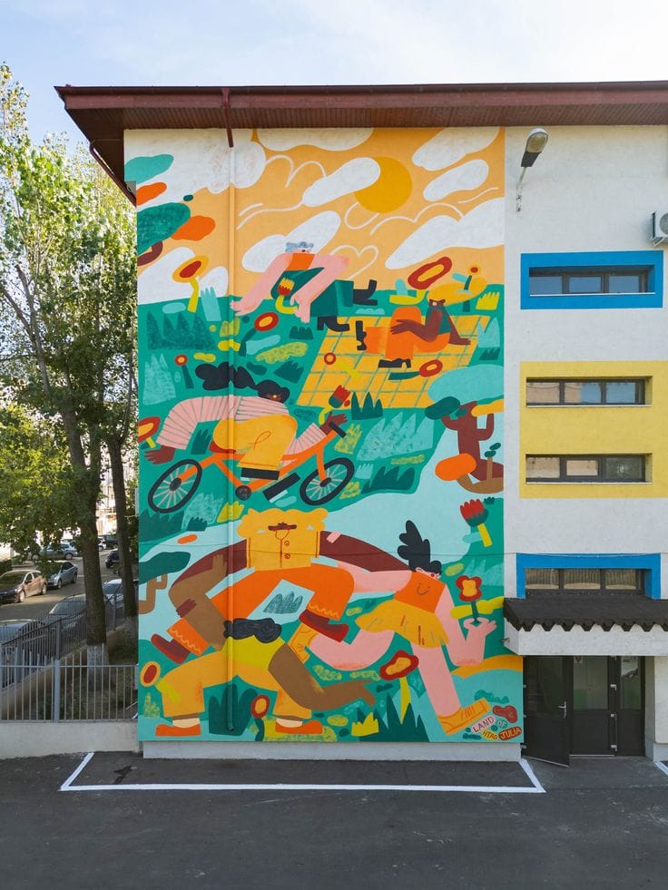 A tall vertical mural on the side of a white building featuring stylized, interconnected figures cycling, running, and picnicking in a lush green and yellow landscape.