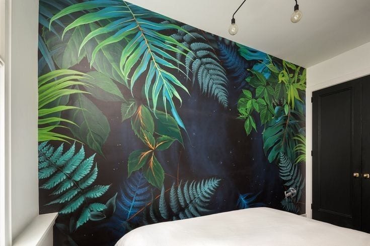 Tropical jungle wall mural in bedroom with green leaves and modern interior design style