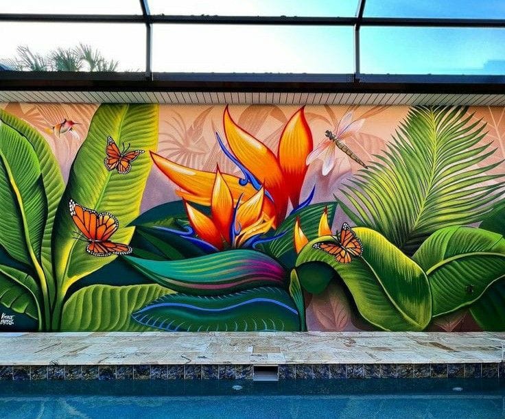 Vibrant tropical patio wall mural featuring bird of paradise flowers, lush green leaves, butterflies, and colorful botanical artwork beside a poolside area.